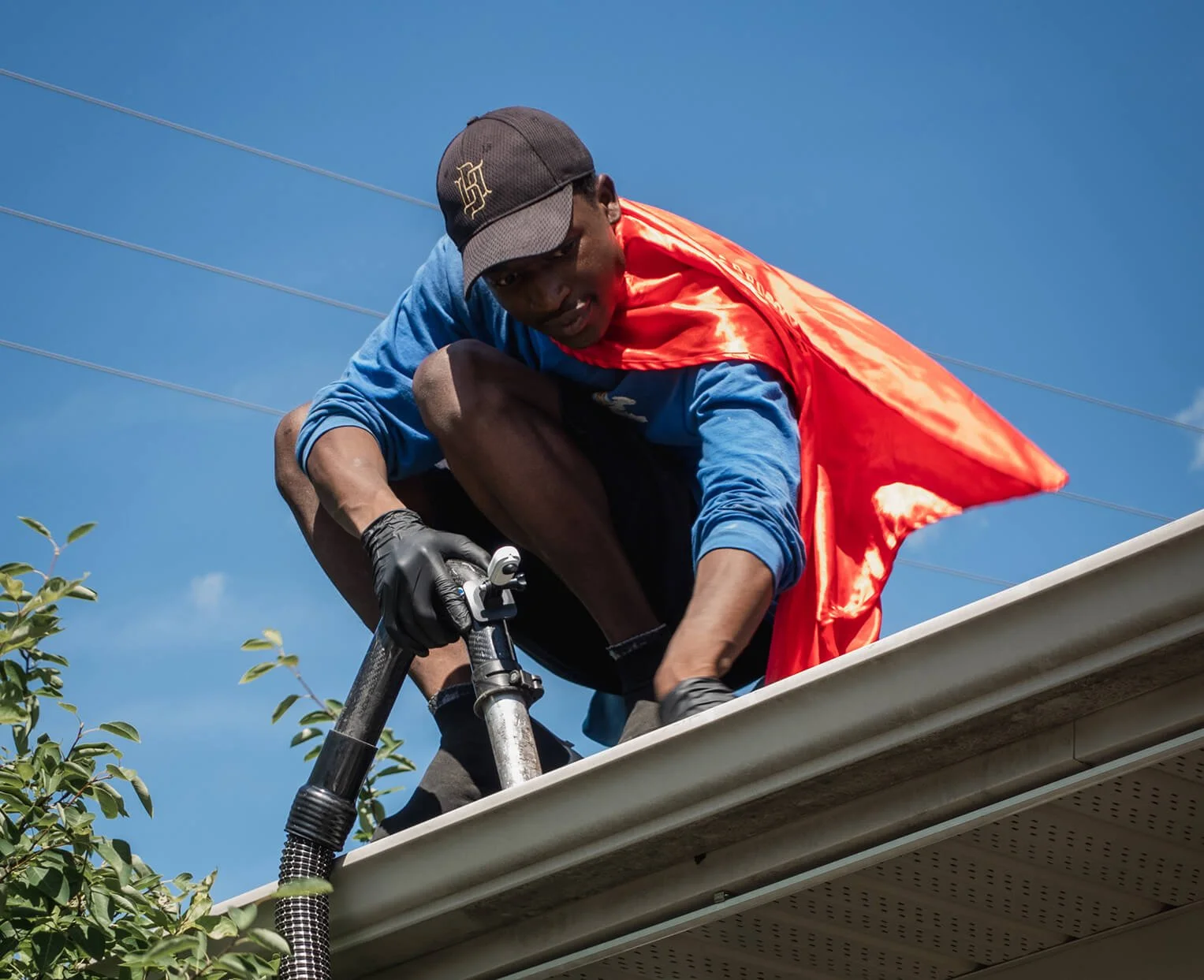 Hero Washing crew member cleaning gutters on roof