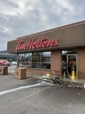 Pressure washing the walkway in front of a Tim Hortons